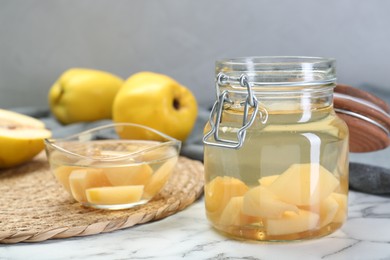 Photo of Delicious quince drink and fresh fruits on white marble table