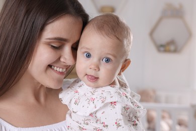 Photo of Happy young mother with her baby daughter at home, closeup