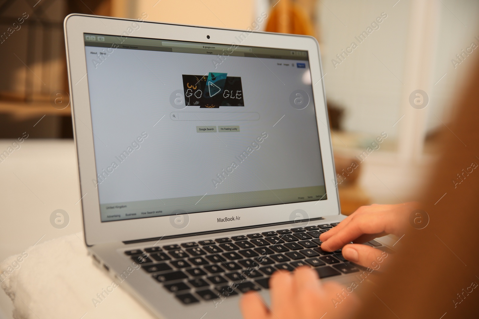 Photo of MYKOLAIV, UKRAINE - OCTOBER 31, 2020: Woman using Google search engine on MacBook Air laptop indoors, closeup