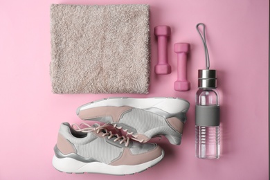 Photo of Flat lay composition of training shoes, towel, dumbbells and bottle on color background