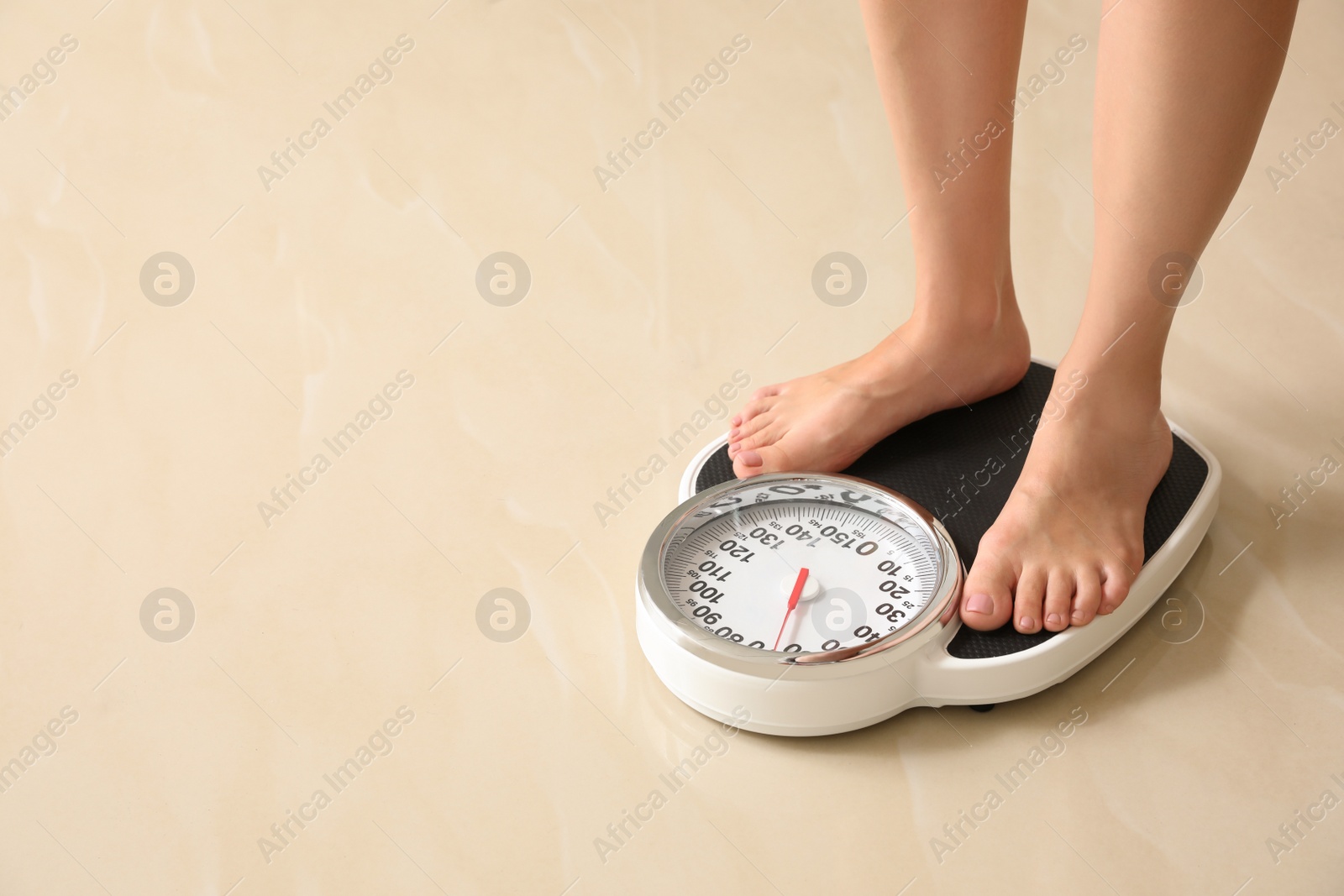 Photo of Woman standing on scales indoors, space for text. Overweight problem