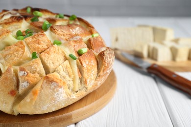 Freshly baked bread with tofu cheese and green onions on white wooden table, closeup. Space for text