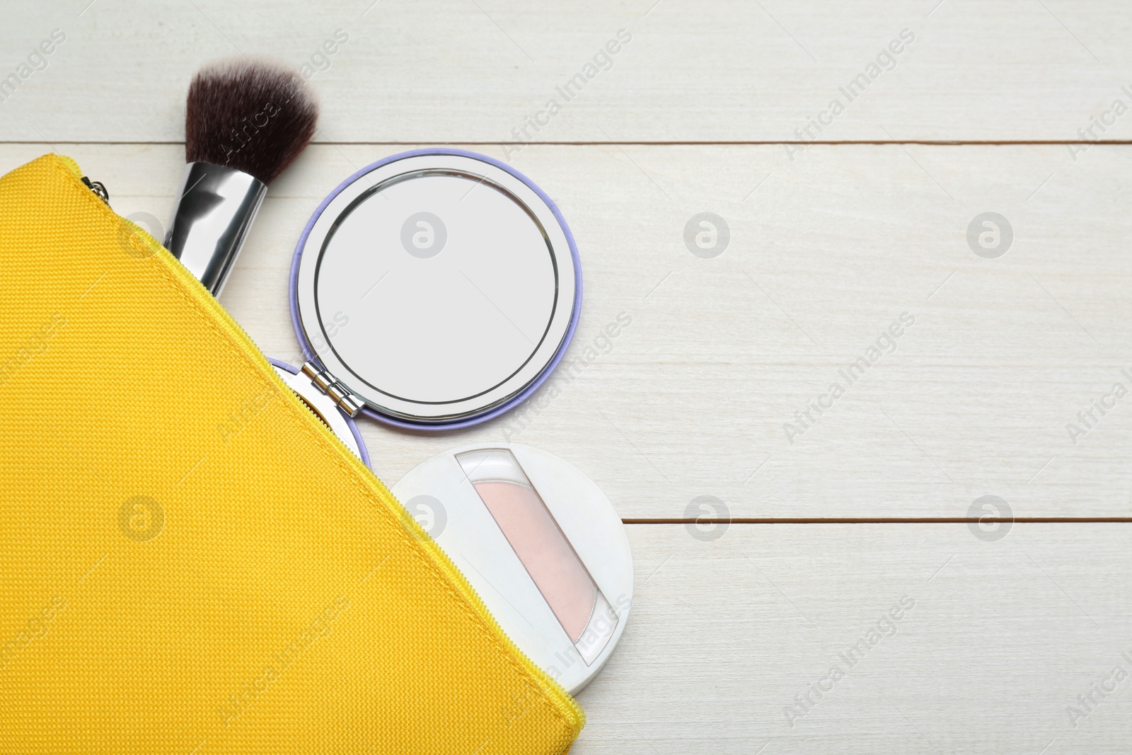 Photo of Stylish pocket mirror, cosmetic bag and makeup products on white wooden table, flat lay. Space for text