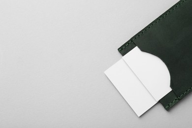 Photo of Leather business card holder with blank cards on light grey background, top view. Space for text