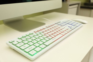 Modern RGB keyboard on white table indoors