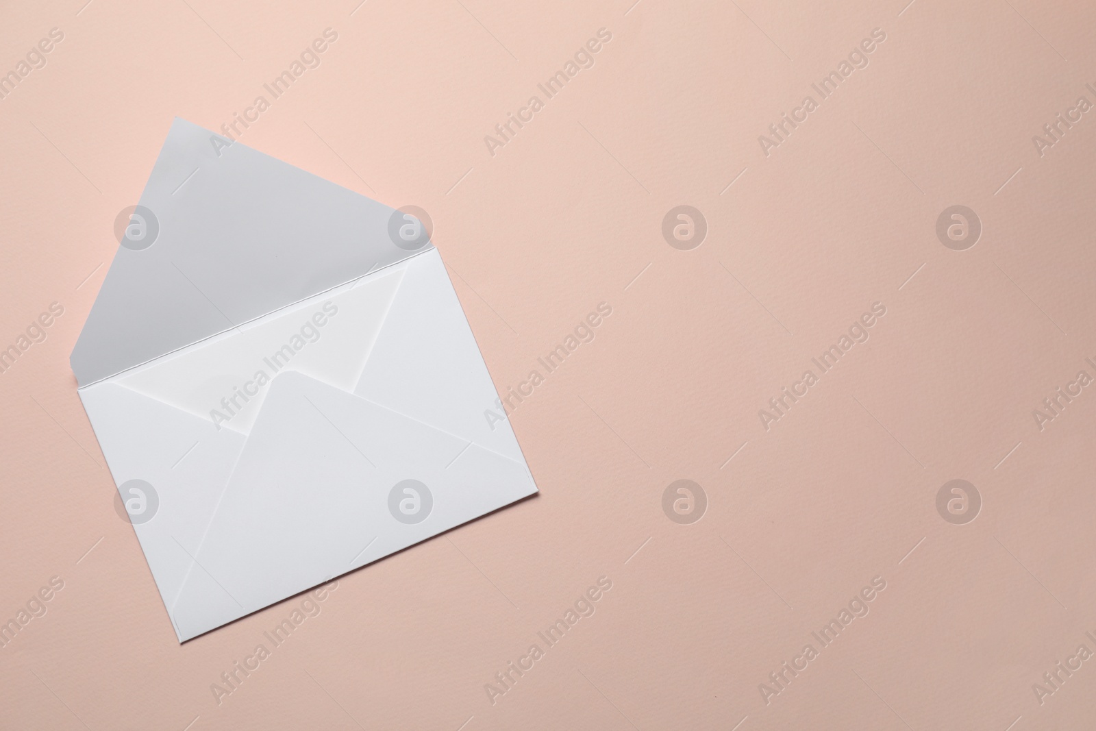 Photo of Letter envelope on beige background, top view. Space for text