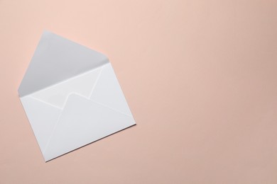 Photo of Letter envelope on beige background, top view. Space for text