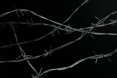 Photo of Shiny metal barbed wire on black background