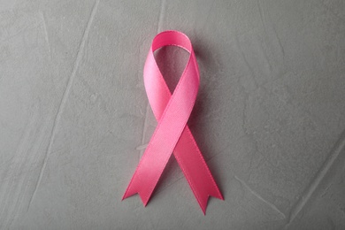 Pink ribbon on grey background, top view. Breast cancer awareness concept