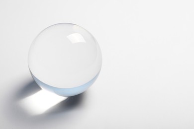 Photo of Transparent glass ball on white background. Space for text
