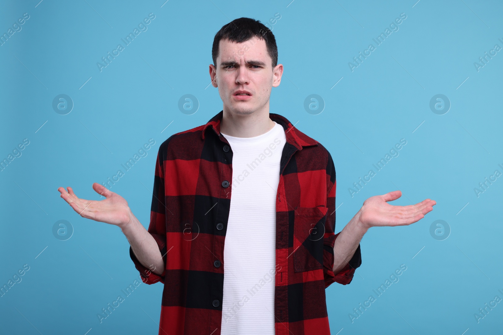 Photo of Portrait of surprised man on light blue background