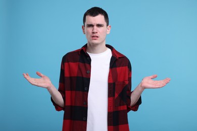 Portrait of surprised man on light blue background