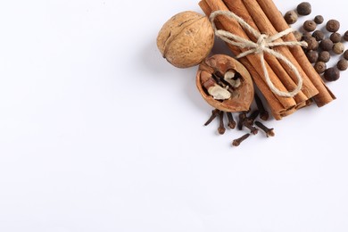 Photo of Different spices and nuts on white table, flat lay. Space for text