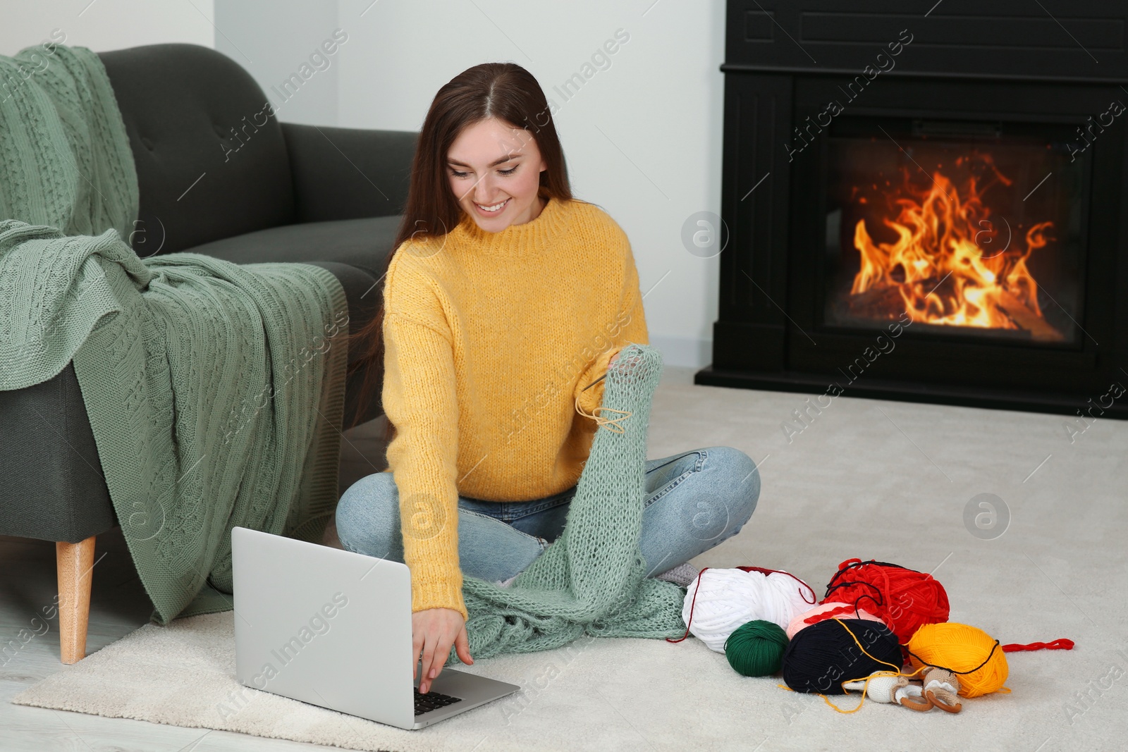 Photo of Young woman learning to knit with online course at home, space for text. Handicraft hobby