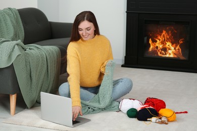 Young woman learning to knit with online course at home, space for text. Handicraft hobby