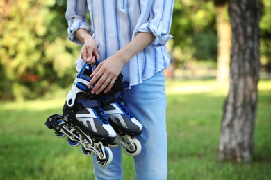 Woman with roller skates in summer park, closeup