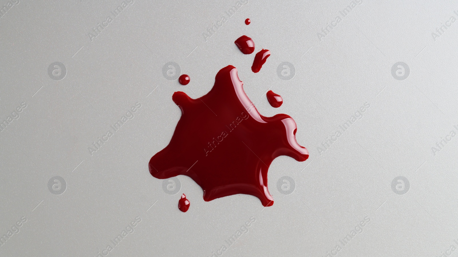 Photo of Stain and drops of blood on grey background, top view