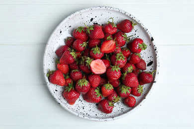 Photo of Delicious ripe strawberries on white wooden table, top view