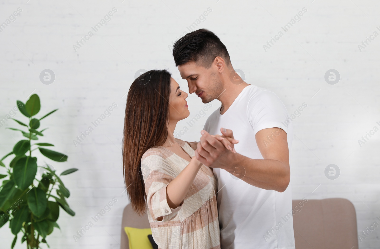 Photo of Happy young couple dancing together at home