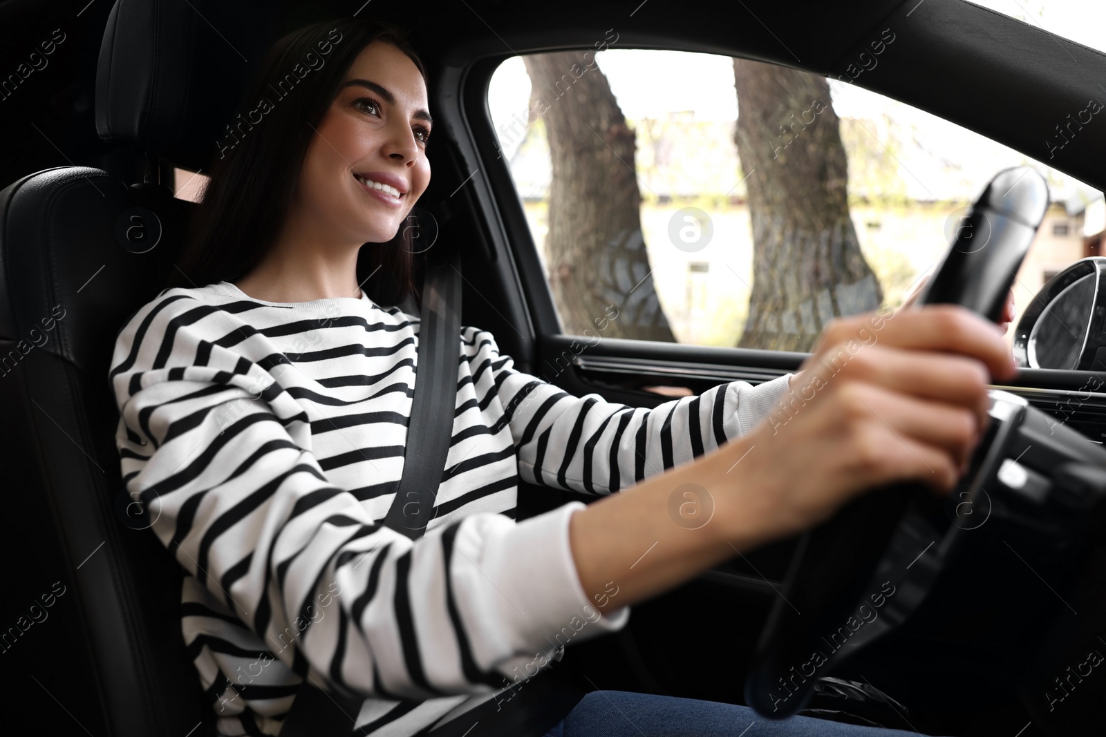 Photo of Woman with safety seat belt driving her modern car