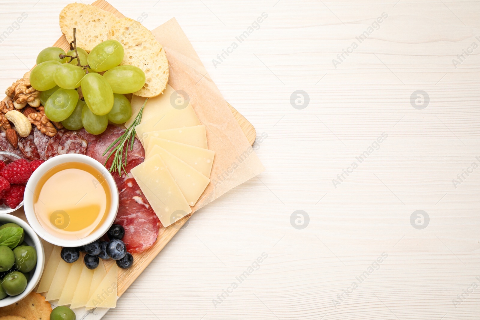 Photo of Snack set with delicious Parmesan cheese on light wooden table, top view. Space for text