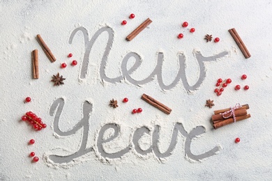 Photo of Flat lay composition with words New Year made of flour on grey table, flat lay