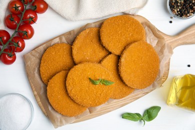 Photo of Delicious fried breaded cutlets served on white table, flat lay