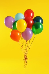 Photo of Bunch of bright balloons on color background. Celebration time