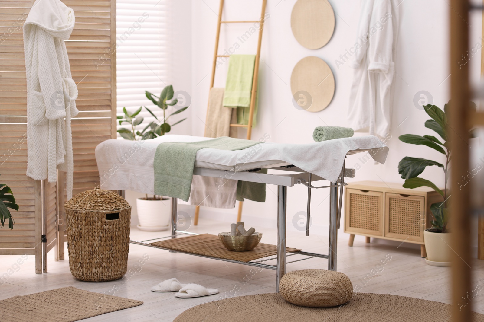 Photo of Comfortable massage table with clean towels in spa center