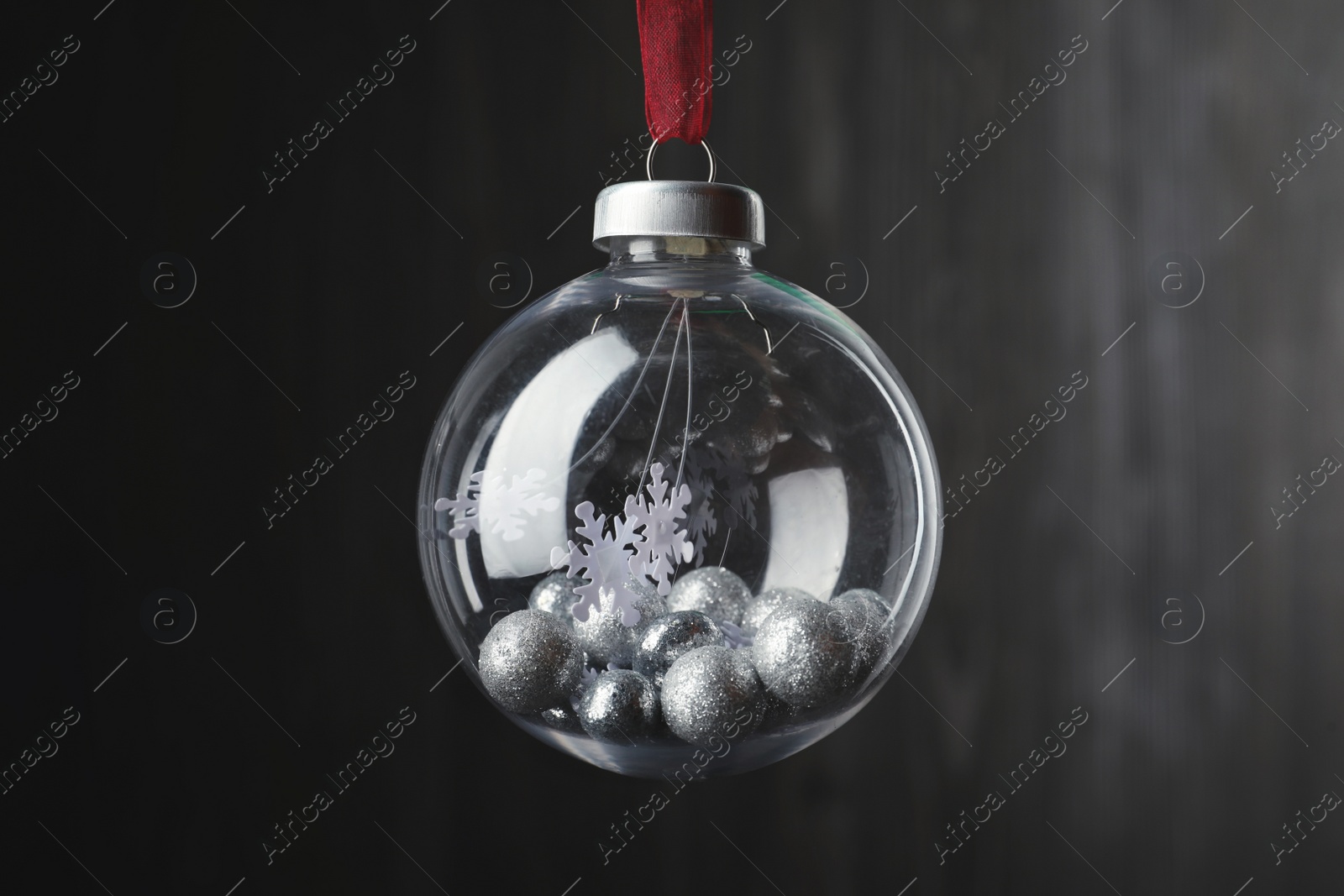 Photo of Beautiful Christmas snow globe hanging on blurred background