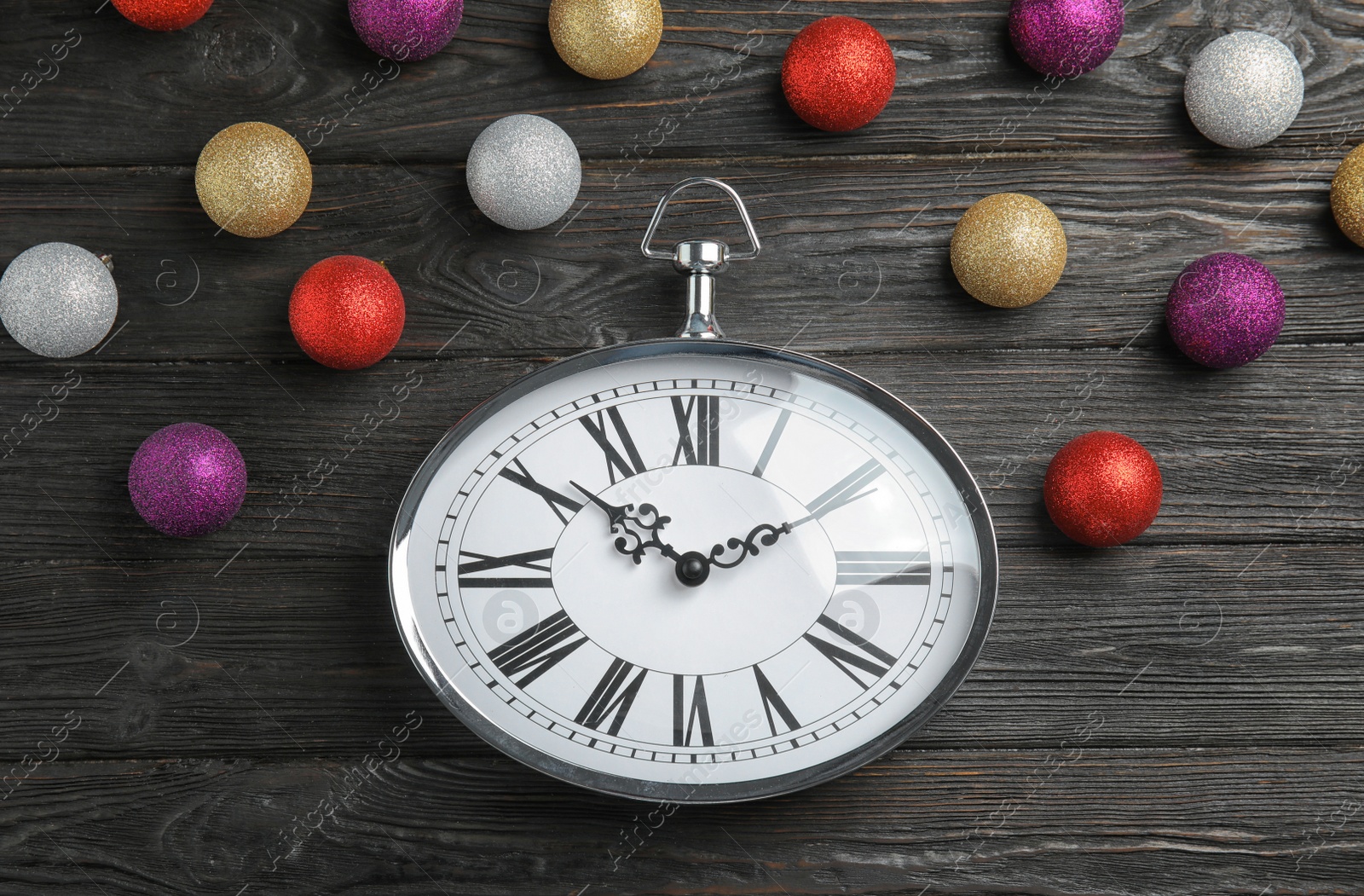 Photo of Flat lay composition with clock and decorations on wooden background. Christmas countdown