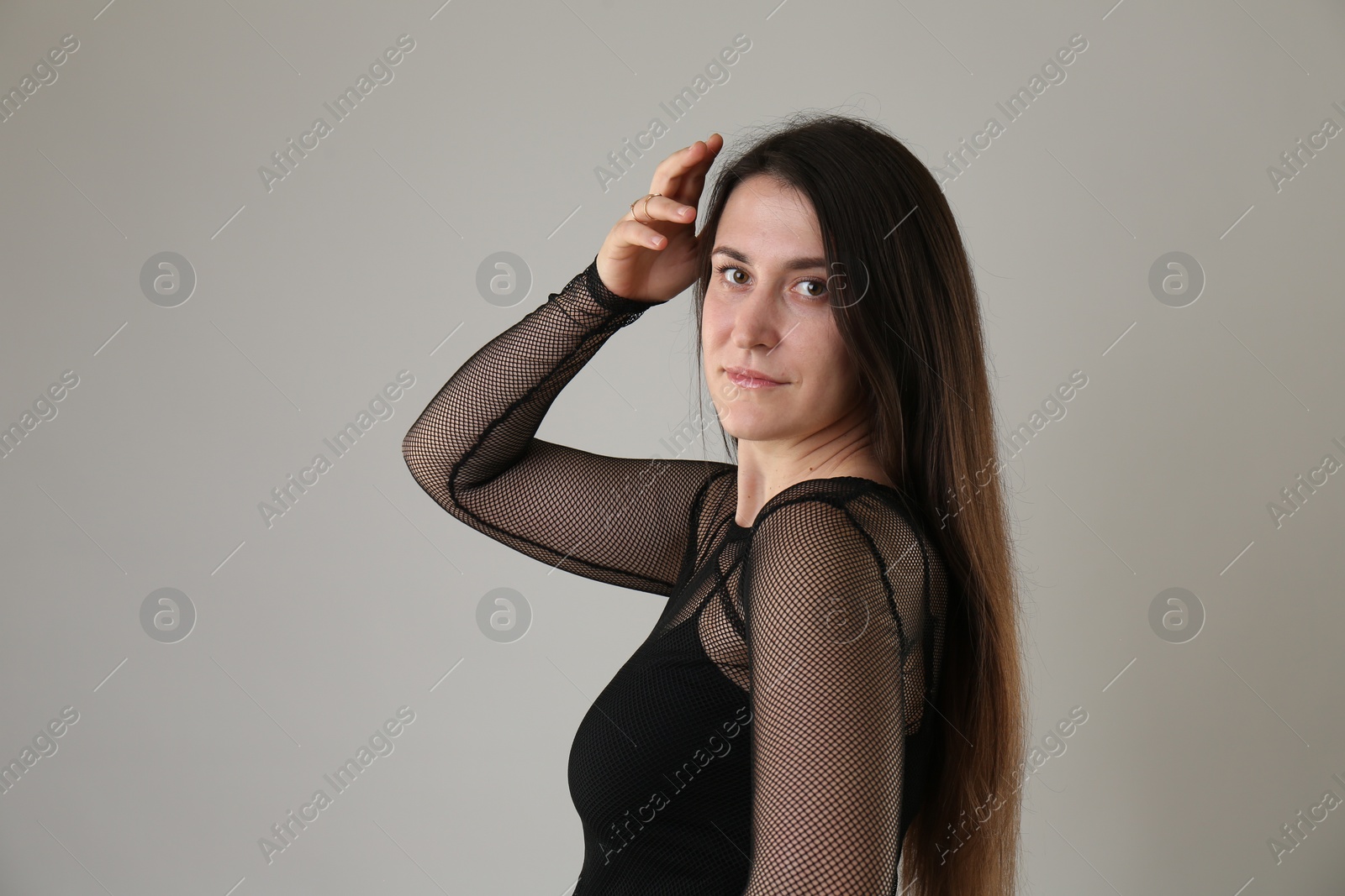 Photo of Portrait of beautiful young woman on light grey background. Space for text