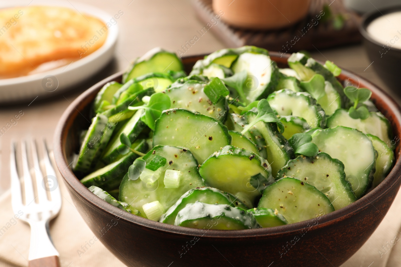 Photo of Delicious cucumber salad on wooden table, closeup