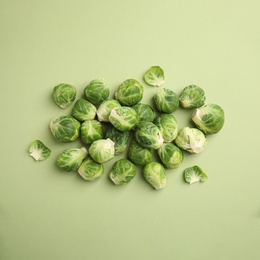 Photo of Fresh Brussels sprouts on green background, flat lay