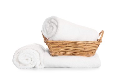Photo of Wicker basket and rolled bath towels isolated on white