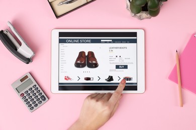 Woman with tablet shopping online on pink background, top view