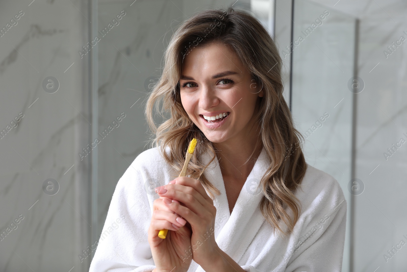 Photo of Beautiful young woman singing into toothbrush in bathroom