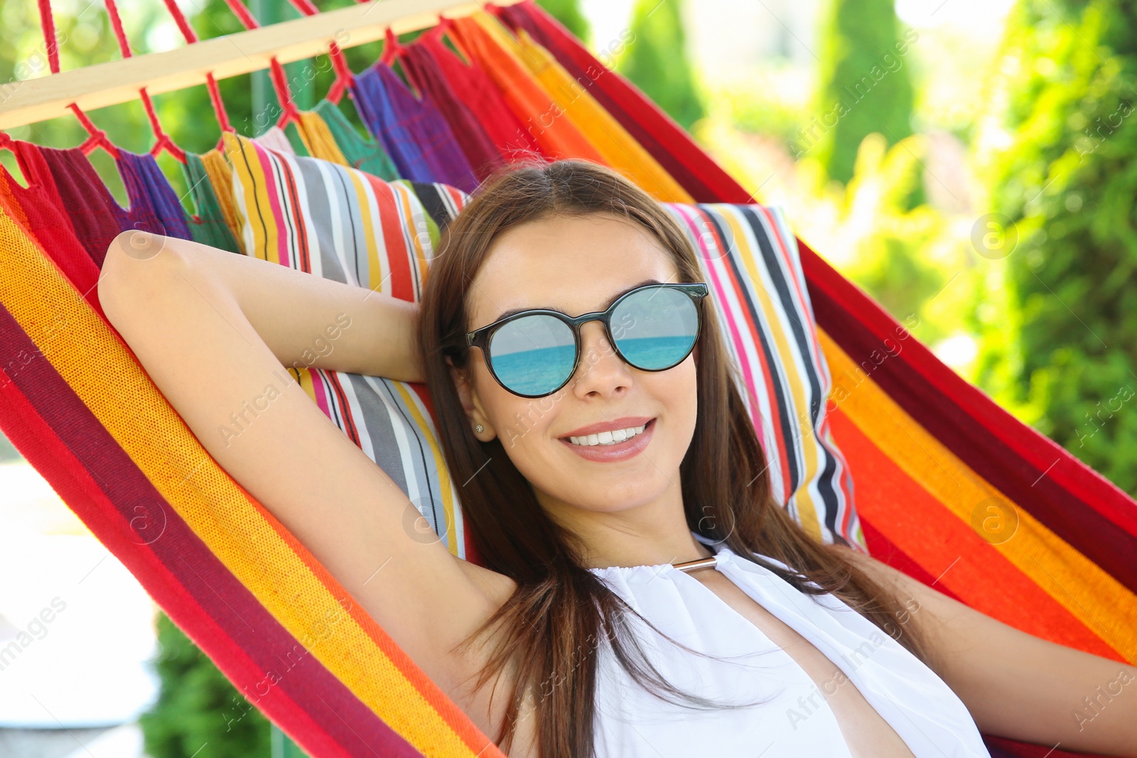 Image of Young woman wearing stylish sunglasses with reflection of sea on warm sunny day 