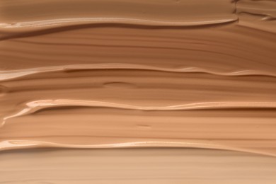 Different shades of liquid foundation as background, closeup