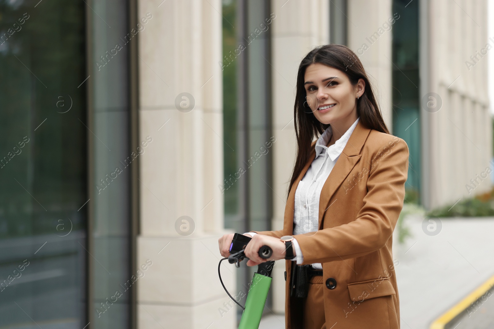 Photo of Businesswoman with modern electric kick scooter on city street, space for text