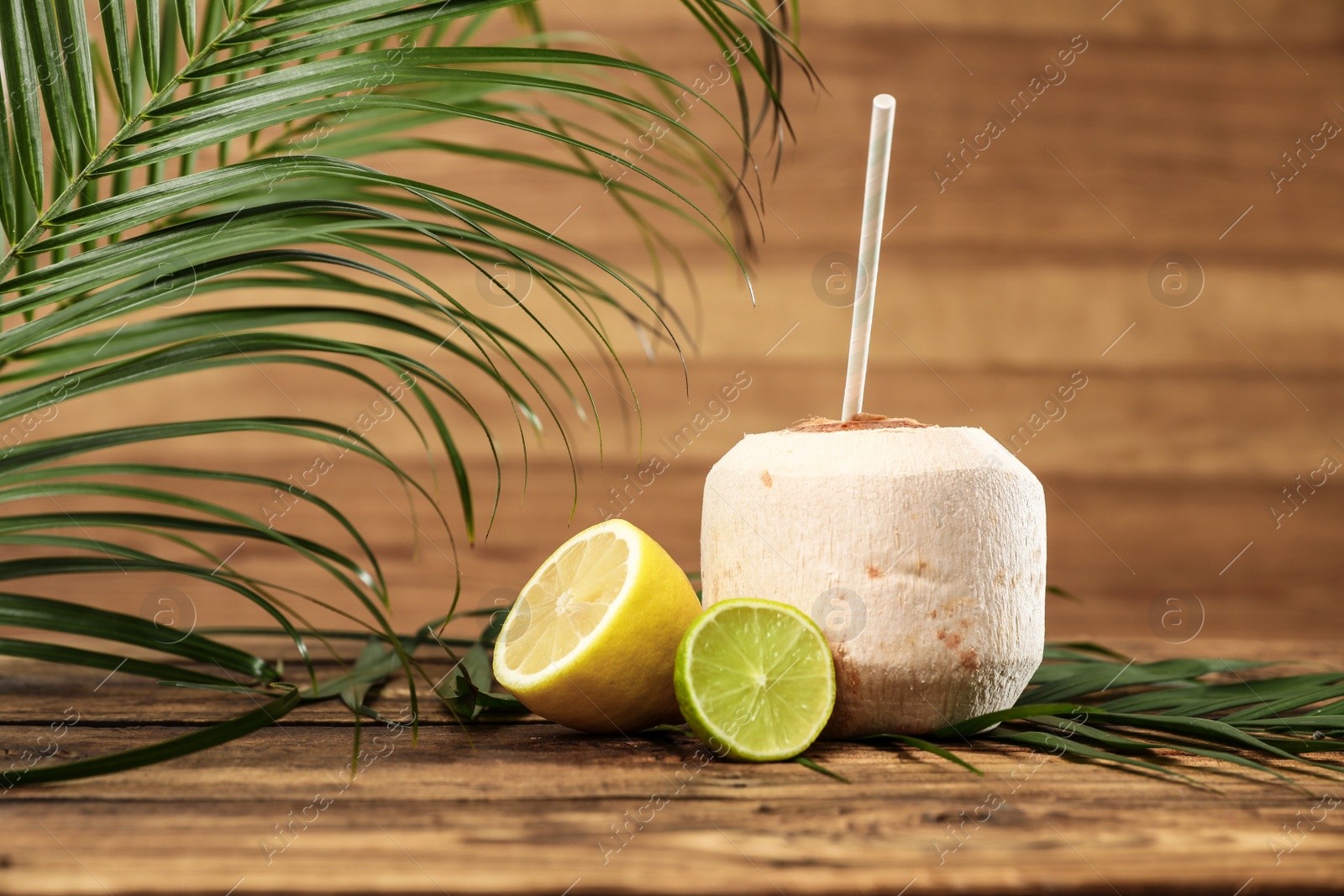 Photo of Open fresh coconut and citrus fruits on wooden table