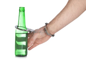 Photo of Man in handcuffs with bottle of beer on white background, closeup. Alcohol addiction