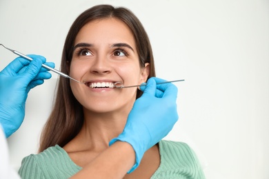 Photo of Dentist examining patient's teeth in modern clinic. Cosmetic dentistry