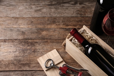 Photo of Composition with wooden crate and bottles of wine on table, space for text