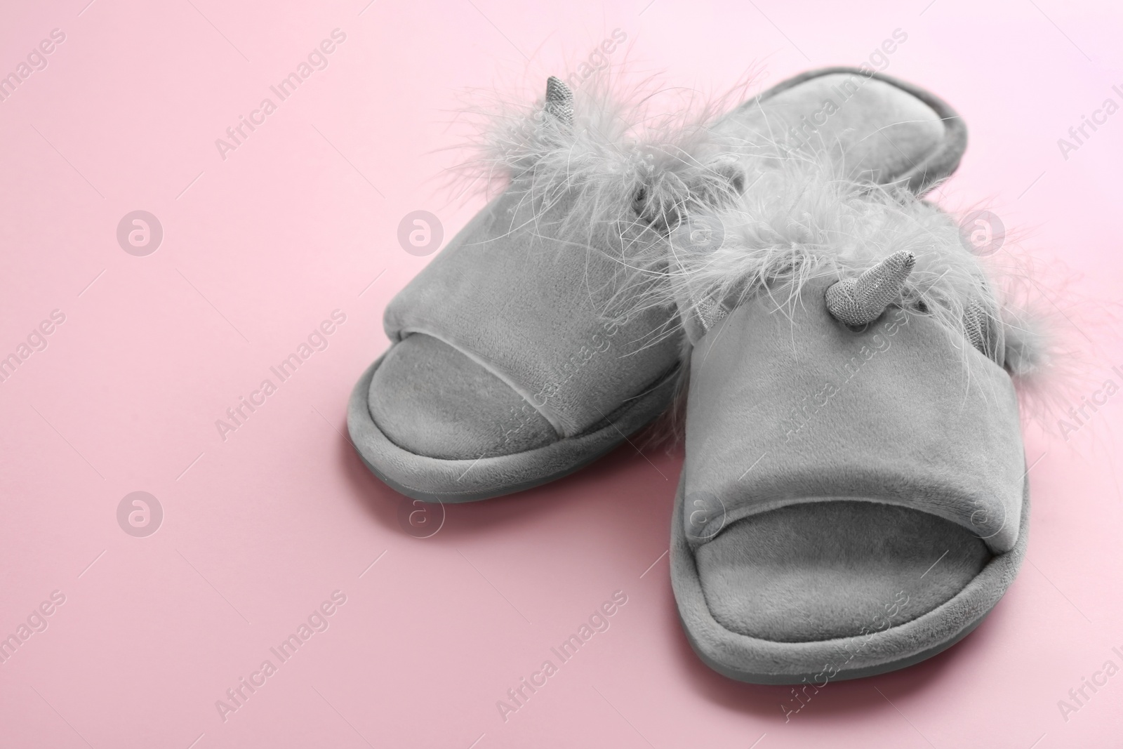 Photo of Pair of stylish soft slippers on pink background. Space for text