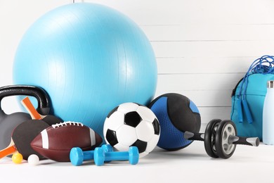 Many different sports equipment on white table