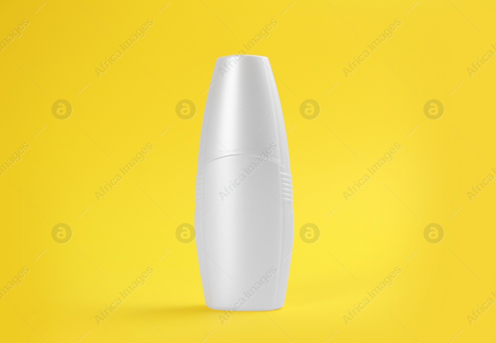 Photo of Bottle with insect repellent spray on yellow background