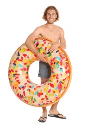 Photo of Attractive young man in swimwear with doughnut inflatable ring on white background