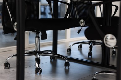 Photo of Comfortable office chairs and table in meeting room, closeup