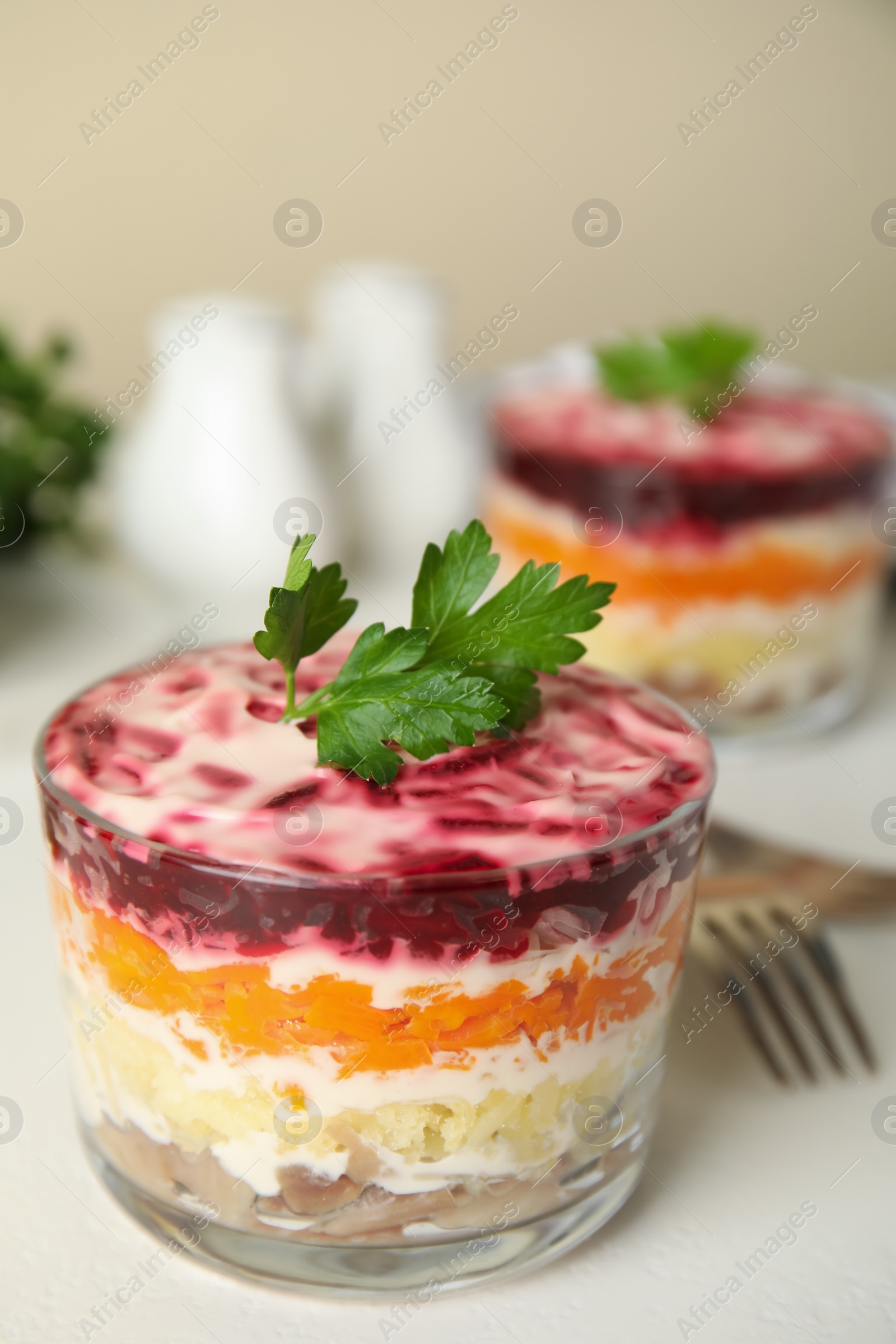 Photo of Herring under fur coat served on white table, space  for text. Traditional russian salad